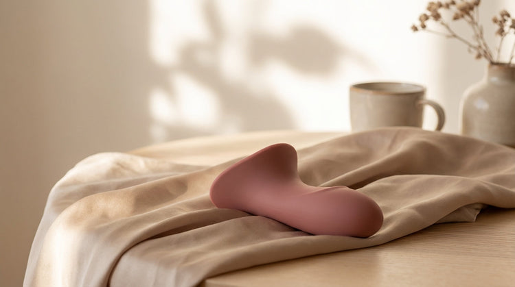 Realistic silicone vibrator on soft silk bedding in a modern interior
