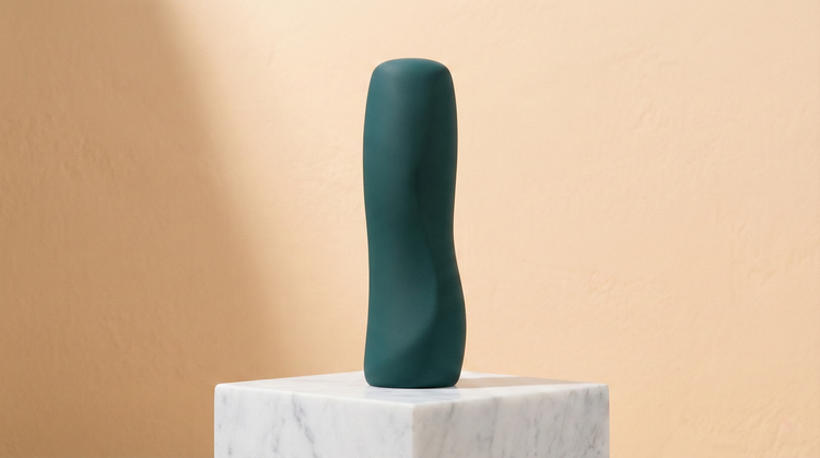 Elegant selection of body-safe dildos and glass pleasure wands, displayed as sculptural art objects in a premium wellness setting.