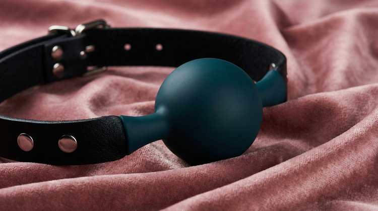Premium silicone ball gag and ring gag restraints, styled as luxury accessories in a safe and sophisticated setting.