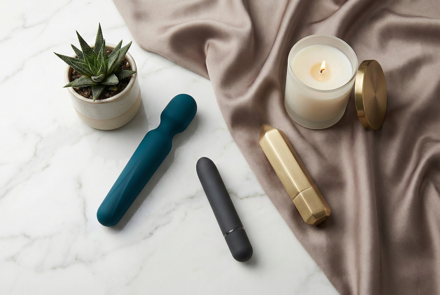 Elegant flat lay display of premium vibrators and luxury sex toys arranged on white marble and silk fabric
