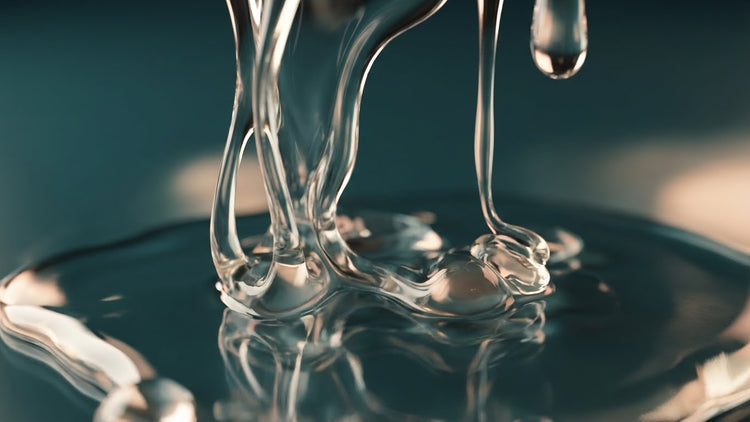 Macro close-up texture of premium anal lubricant gel showing thick viscosity and smooth glide on a deep teal background.