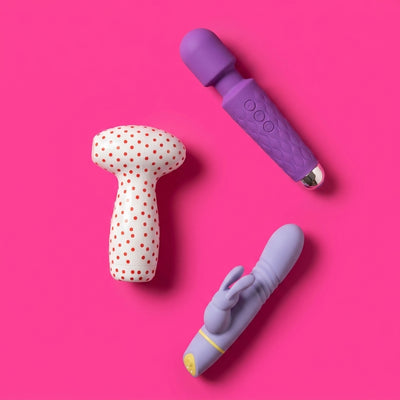 Three premium vibrators arranged on a vivid pink background — vibrators and intimate wellness devices for women at NaughtyNest UK
