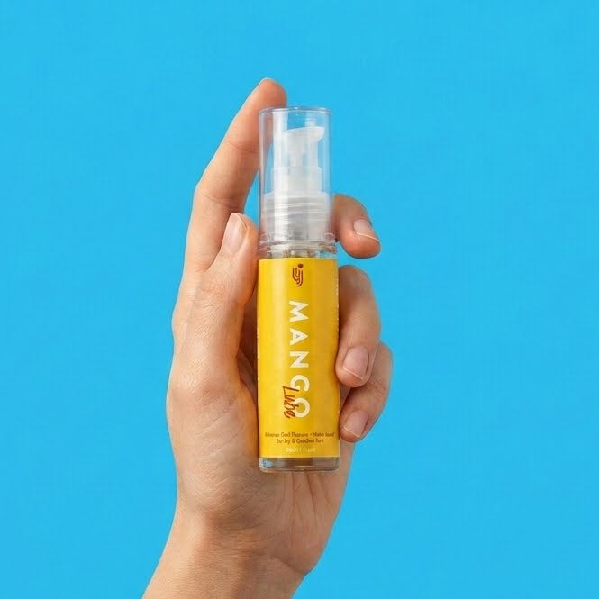 Slim matte lubricant bottle held in hand on vivid cyan background — intimate lubricants and personal care at NaughtyNest UK