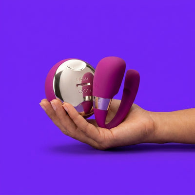 Lubricant bottle held gently in hand against vivid cyan background — personal lubricants and intimate care products at NaughtyNest UK