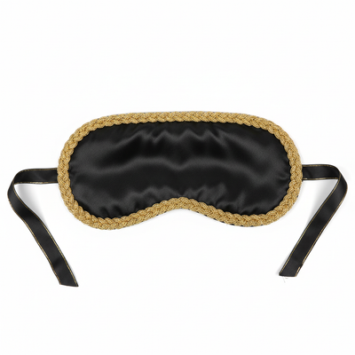 Luxurious black satin blindfold with gold trim on white background