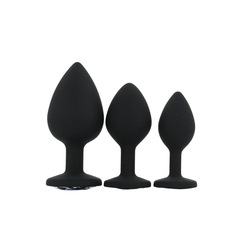 Three black silicone butt plugs of different sizes on a white background
